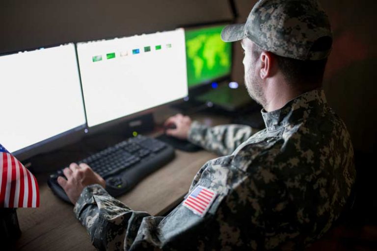 Military IT person in fatigues using a computer